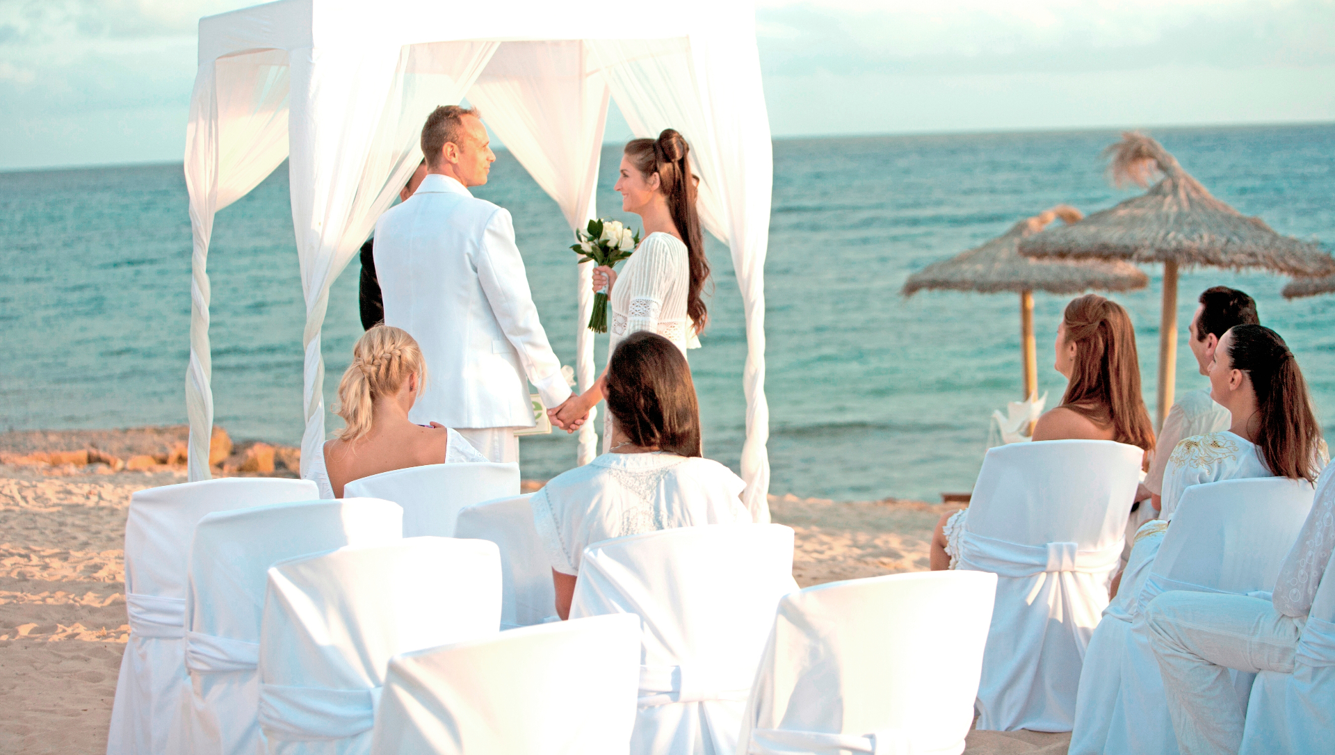 Ceremonia de boda con altar blanco frente al mar